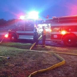 Firefighters with hose and fire truck